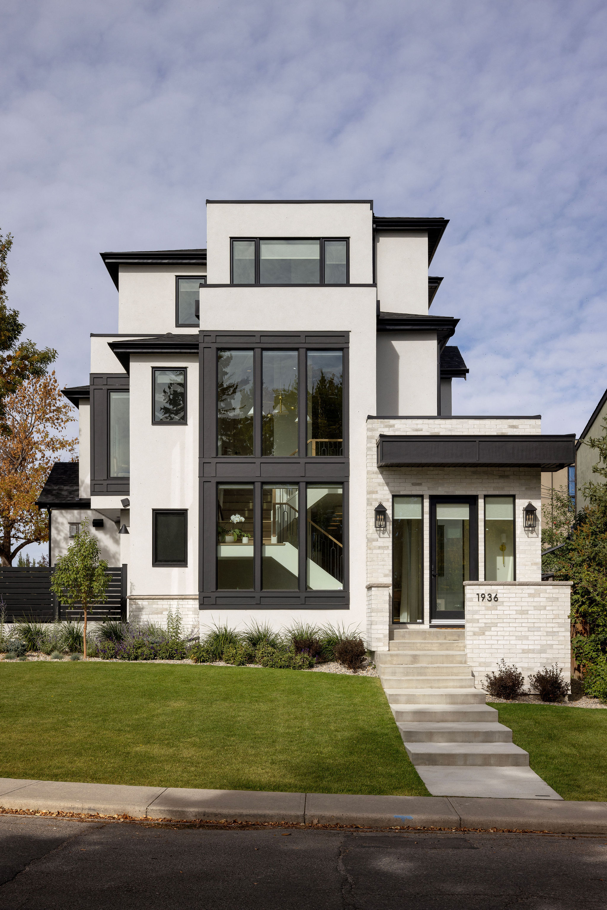 Three-storey white home with black-framed windows