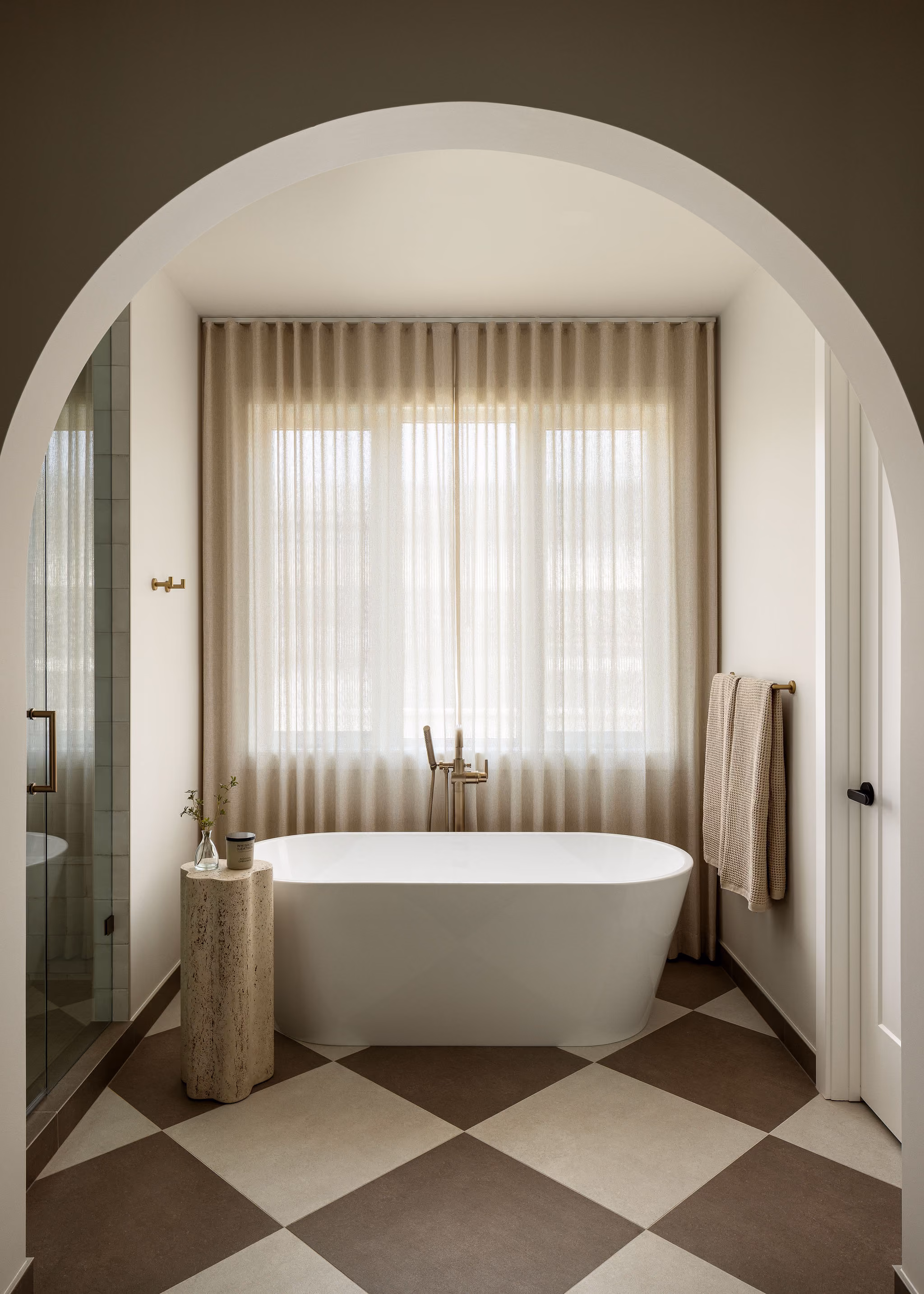 Freestanding tub seen through an arched doorway